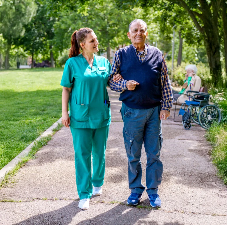 Astar Homecare carer sharing a walk with an elderly man outdoors, offering companionship and social support services.