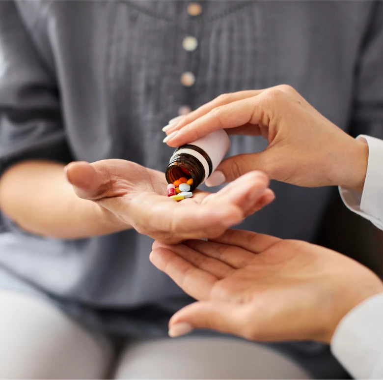 Astar Homecare carer providing daily medication support, handing pills to an elderly person to ensure safety and wellbeing.